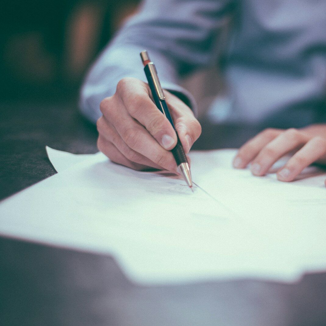 man writing on paper